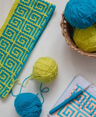 Sarı mavi pamuklu örgü işi, iplik yumakları, kanca ve not defteri. El yapımı konsept.