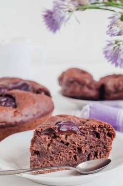 Bir parça taze çikolatalı kek bir şenlik masasına yakın duruyor..