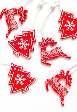 Kırmızı beyaz ren geyiği ve Noel ağacı süsü. Beyaz arka planda tahta Noel oyuncakları. Ahşap dekor. Sıfır atık.