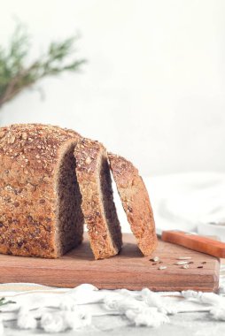 Tahtaya tohum konmuş bir somun taze çavdar ekmeği. Sağlıklı ekmekle kahvaltı. Boşluğu kopyala.