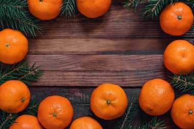 Taze mandalinalar, mandallar ve köknar dalları olan bir Noel çerçevesi. Boşluğu kopyala.