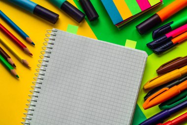 Renkli okul malzemeleri ve renkli bir arka planda bir defter. Okul kavramı.