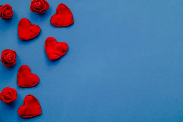 青い背景に赤いハートと赤いバラ バレンタインデーのグリーティングカード スペースのコピー ロイヤリティフリーのストック写真