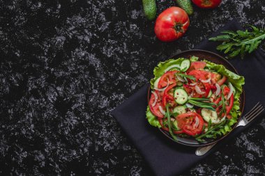 Salatalıklı, domatesli, roka, soğanlı ve kırmızı biberli taze sebze salatası. Üst Manzara. Boşluğu kopyala.