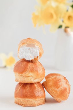 Lezzetli kahvaltı için krem şantili küçük yuvarlak ekler ya da profiteroller. Geleneksel Fransız ekleri.