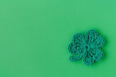 Yeşil örgü yonca ya da yeşil arka planda yonca yaprağı. Aziz Patrick Günü dekorasyonu. Üst Manzara. Boşluğu kopyala.