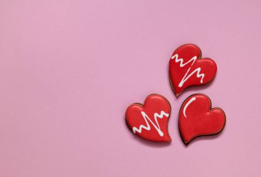 Red heart shaped cookies on a pink background for Valentine's day. Love concept. Top view. Copy space.
