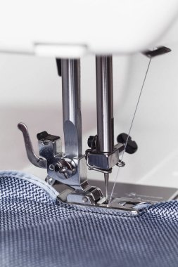 Modern dikiş makinesinin ayağını kapat. Çalışma süreci.