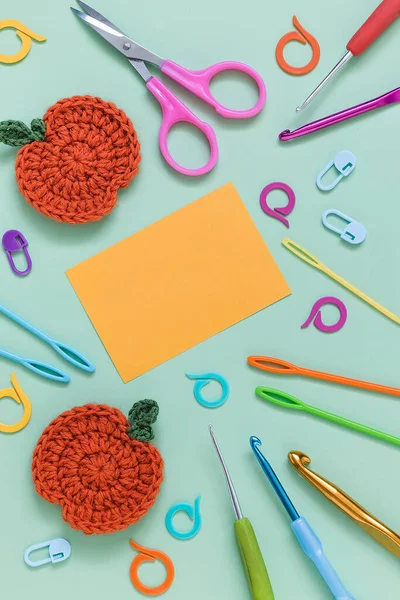 stock image Blue background with crochet pumpkin, crochet tools and yellow paper blank. Copy space.