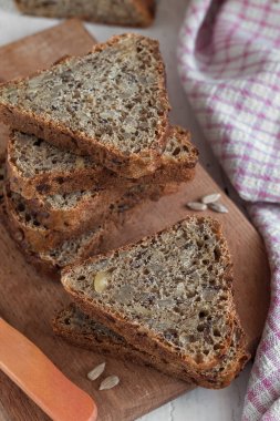 Tahta bir tahtanın üzerinde ay çekirdeği ile üçgen şeklinde dilimlenmiş ekmek. Sağlıklı yeme kavramı.