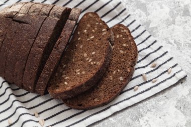 Çizgili tekstil üzerinde koyu kepekli çavdar ekmeği..