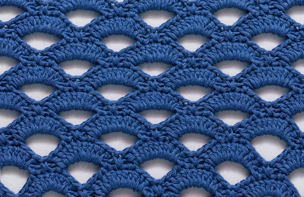 Blue seamless crochet texture with holes. Crochet arcade stitch.