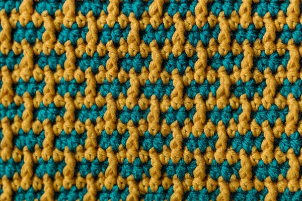 Seamless green yellow crochet fabric with brick pattern. Knitted background.