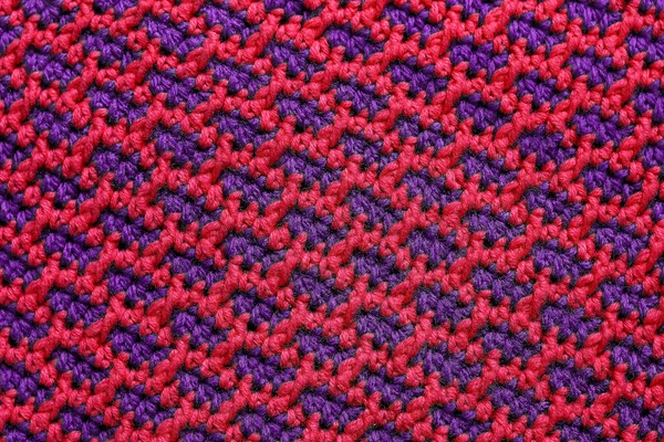 Seamless pink purple crochet fabric with brick pattern. Knitted background.