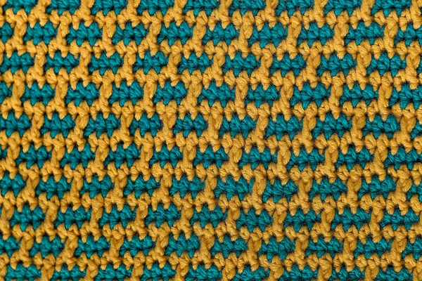 Knitted fabric texture. Seamless yellow green crochet fabric with brick pattern.