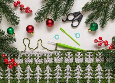 Tığ işi kumaş, toplar ve köknar ağacı dallarıyla Noel kompozisyonu. Noel ağacı süsüsüyle örgü örmek.