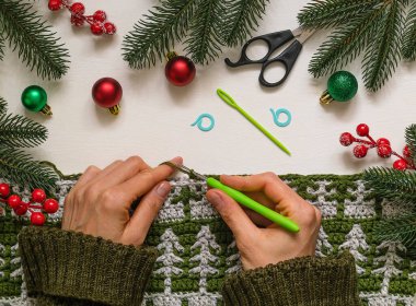 Noel ağacı desenli bir tuval ören bir kadın..