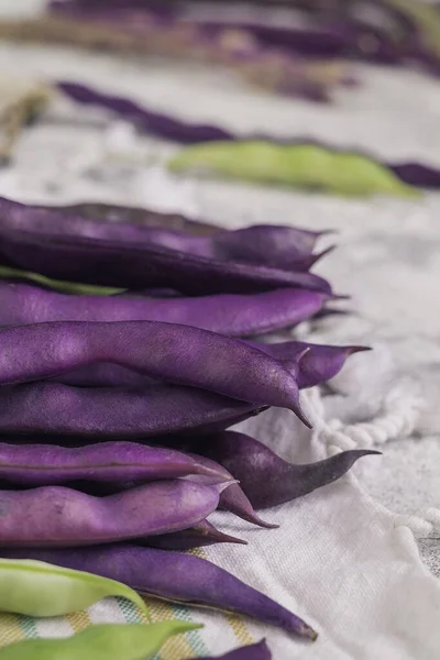 Fresh purple bean pods Blauhilde on a table. Fresh haresd.