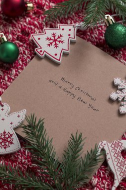 Kırmızı örgü arkasında Noel oyuncakları olan el işi tebrik kartı. Üst Manzara. Boşluğu kopyala.