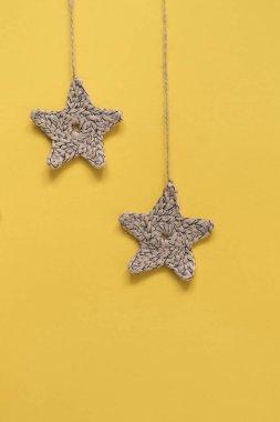 Sarı arkaplandaki bej örgü yıldızı. Boşluğu kopyala.