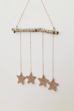 Duvar örgü yıIdızı süslemesi beyaz bir duvara asıIı. Boşluğu kopyala.