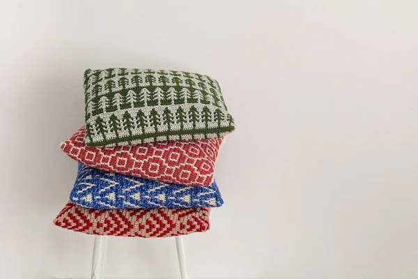 白い背景に椅子の上に4つのカラフルなかぎ針編み枕のスタック コピースペース ストック写真