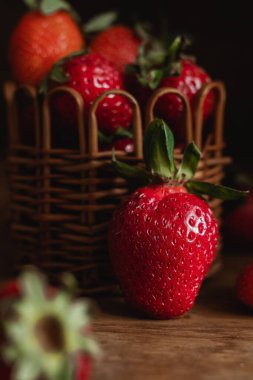 Taze kırmızı çilek yakından. Tahta bir masada taze çilekli sepet..