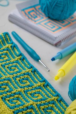 Mozaik desenli sarı mavi örgü kumaş. Tığ işi kumaşlı bir işyeri. Kadınların hobi konsepti.