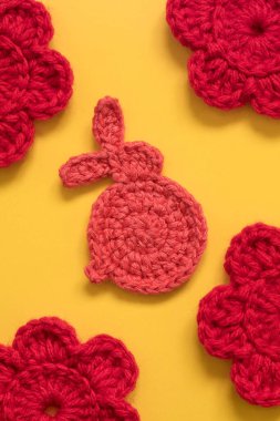 Paskalya örgü örer tavşanı sarı arka plana yakın durur..