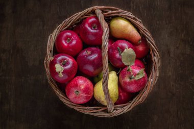 Tahta bir arka planda hasır sepette taze organik kırmızı elmalar. Üst Manzara. Boşluğu kopyala.