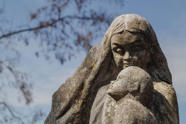 Mavi gökyüzü arka planında çocuk taş heykeli olan anne. Novograd - Volynsky, Zhytomyr bölgesi, Ukrayna.