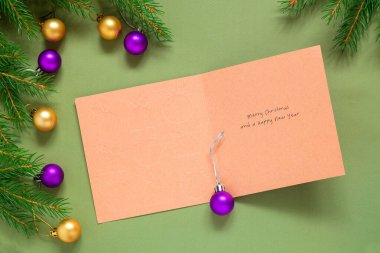 Boş kartpostallı Noel kompozisyonu, ladin dalları, mor ve altın takı. Uzayı kopyala Model yap. Üst görünüm.