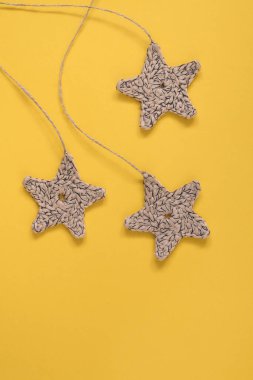 Sarı arka planda üç örgü yıIdızı. Uzayı kopyala Çevre dostu dekorasyon.