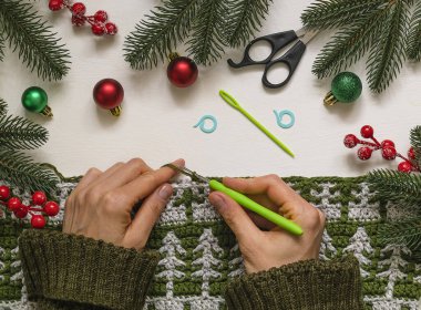 Noel ağacı desenli bir tuval ören bir kadın..