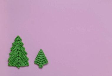 Eflatun arka planda iki örgü yeşili Noel ağacı oyuncağı. Üst Manzara. Boşluğu kopyala.