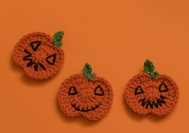 Turuncu arka planda üç Cadılar Bayramı örgü kabağı. Üst Manzara. Boşluğu kopyala.