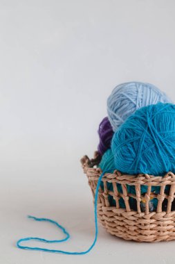 Beyaz arka planda sepette mavi iplik topları. Uzayı kopyala Serbest ve yaratıcı çalışma kavramı.