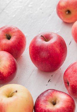 Beyaz ahşap arka planda taze kırmızı elmalar. Yan görünüm.