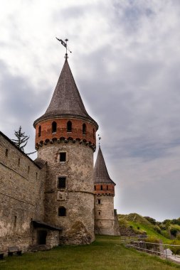 Görkemli ortaçağ kalesinde, tarihi önemi ve mimari güzelliği vurgulayan, canlı yeşilliklerle bezenmiş yüksek kuleler ve engebeli taş duvarlar yer alıyor.