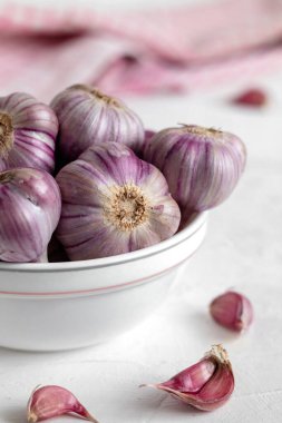 Masadaki beyaz kasede mor çizgili sarımsak..