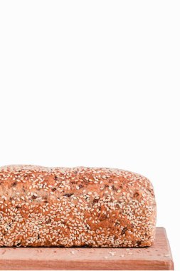 Beyaz arka planda tahta bir tahtada taze susamlı ekmek. Yan görüş. Boşluğu kopyala.