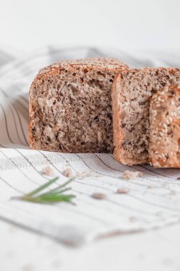 Biberiyeli açık masa örtüsünün üzerinde susam tohumlu tam tahıllı ekmek. Glütensiz ekmek..
