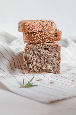 Tahtada dilimlenmiş susamlı ekmek, bıçak ve süt botu. Sağlıklı beslenme konsepti. Glütensiz ekmek..