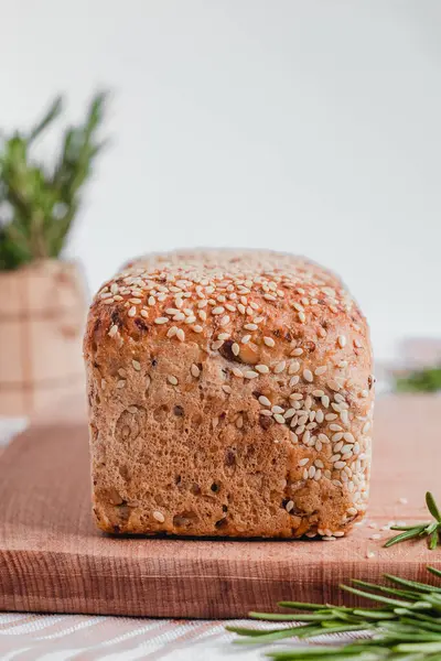 Tahtaya susam tohumu ve biberiye serpiştirilmiş taze ekmek. Sağlıklı pişmiş ekmek. Boşluğu kopyala.