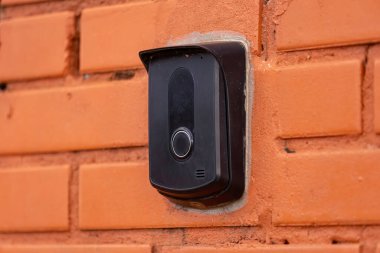 Tuğla duvardaki siyah bir dahili iletişim cihazını kapat