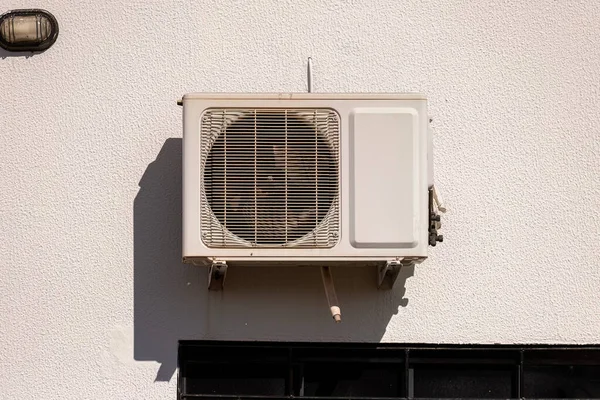 Beyaz bir duvara yerleştirilmiş klima kondansatörü