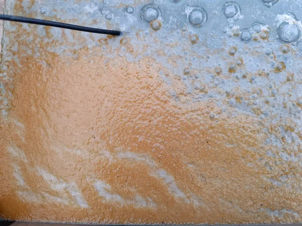 water surface in aquarium with bubbles and rust due to an experiment electrolysis process to remove rust from metals
