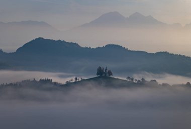 Cerkev Sveti Tomas (St. Thomas Church) near Skofja Loka, Slovenia. Misty morning and sunrise