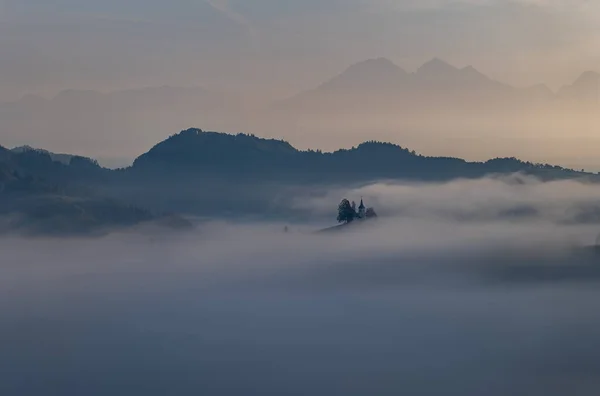 Cerkev Sveti Tomas (St. Thomas Church) near Skofja Loka, Slovenia. Misty morning and sunrise