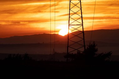 Fiery sunrise in autumn in Czech Moravia and power lines